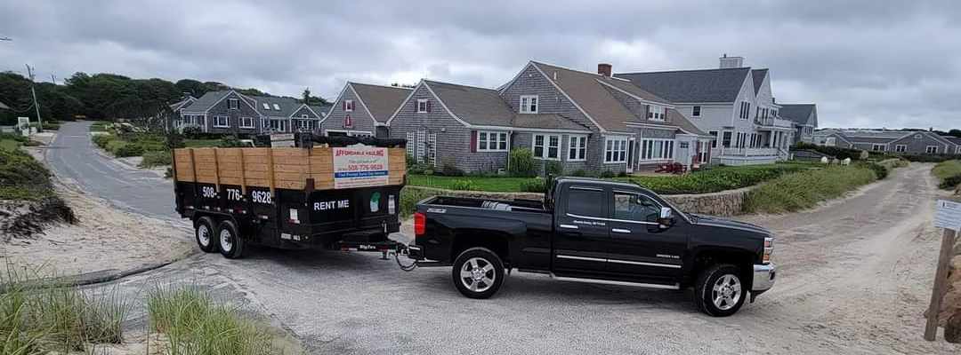 Panooramic view of an Affordable Hauling truck and trailer in front of a home in Cape Cod.