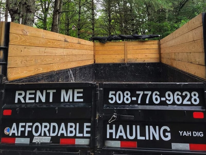A view of an empty trailer for rent wth Affordable Hauling phone number.